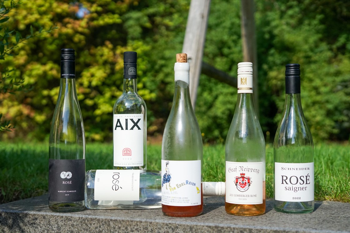 Sechs Flaschen Rosé. überwiegend leergetrunken, nebeneinander auf einer Stufearrangiert